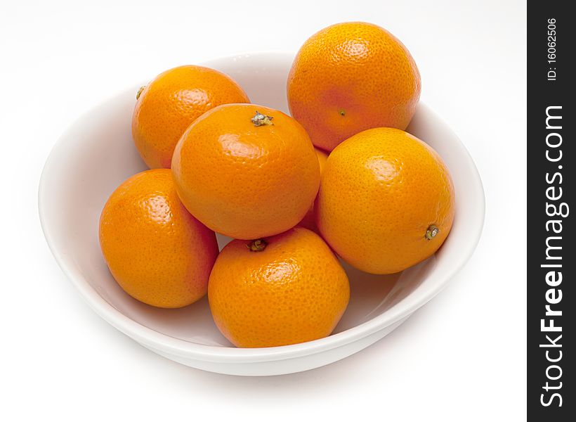 White ceramic bowl with orange mandarines. White ceramic bowl with orange mandarines.