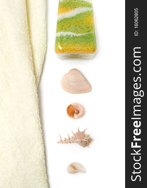 Soft pleasant towel and ocean salt with seashells on white. Soft pleasant towel and ocean salt with seashells on white