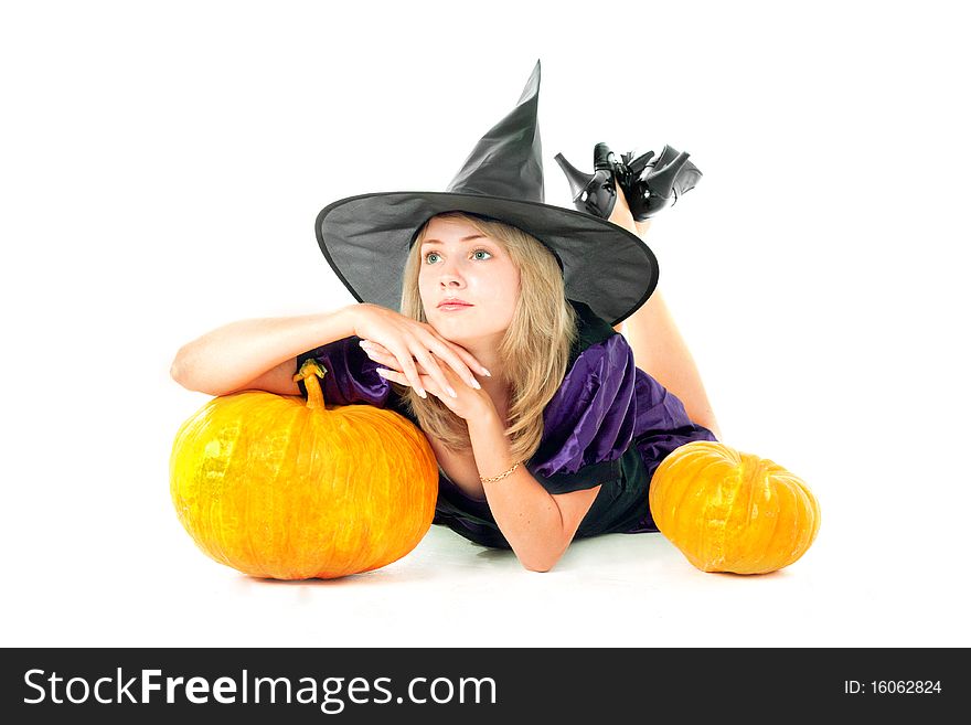 Young blond girl witch sitting beside pumpkins