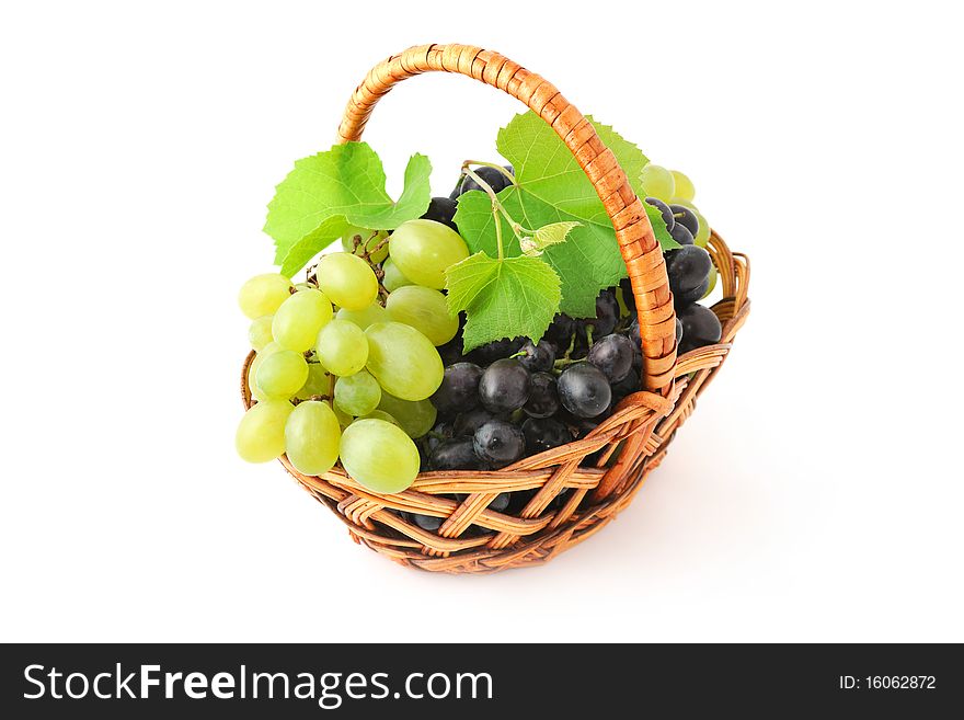 Basket with ripe green and blue grapes and leaves. Basket with ripe green and blue grapes and leaves