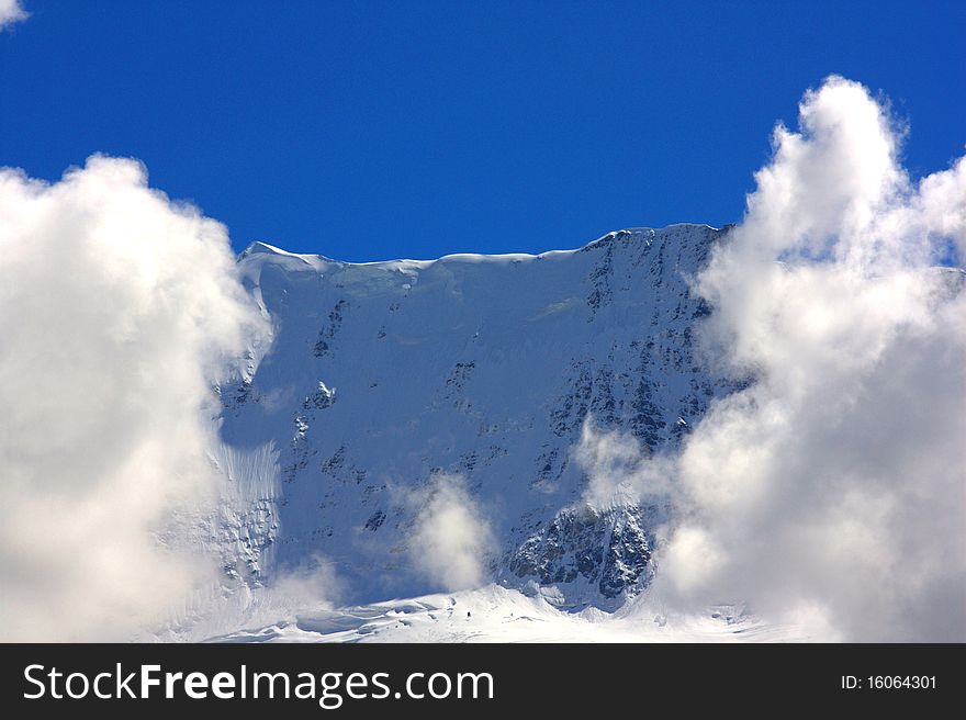 Mountain top flanked by clouds