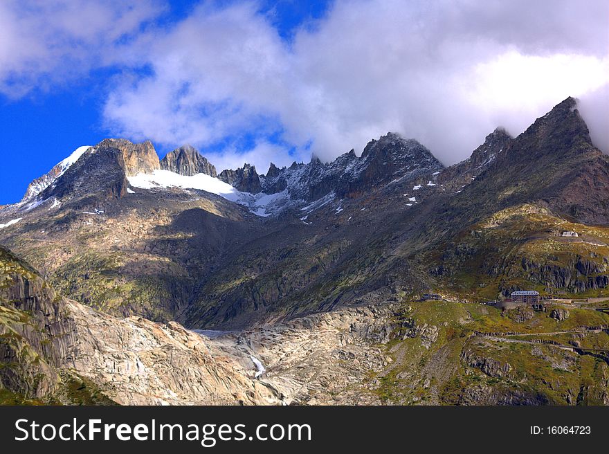 Clouds above a snowy mountain above a glacier