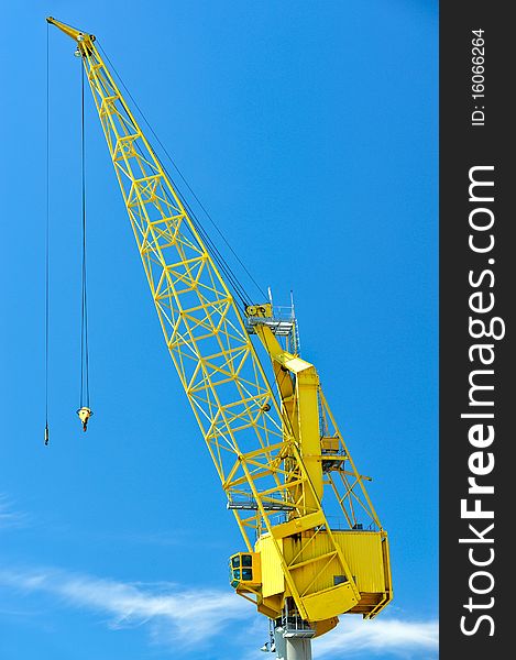 Yellow crane against blues sky with cloud