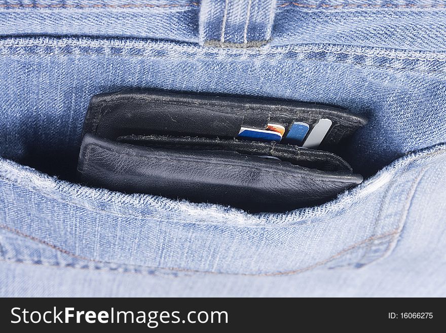 Purse with credit cards in a pocket of jeans.