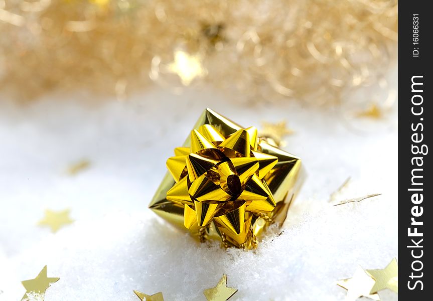 Golden gift in snow with stars