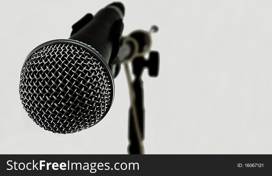 Modern microphone with depth of field view against light white background. Modern microphone with depth of field view against light white background