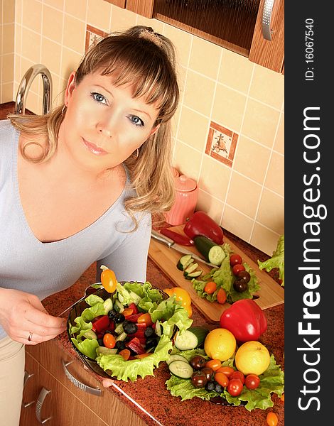 Adult woman preparing salad at domestic kitchen