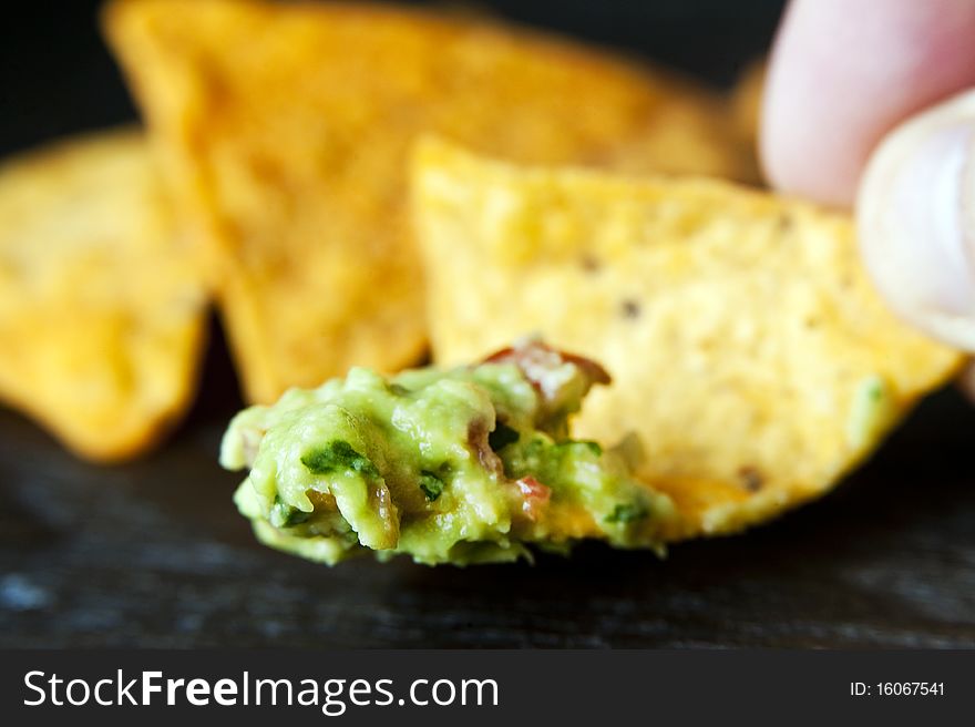 A crunchy nacho with some delicious guacamole