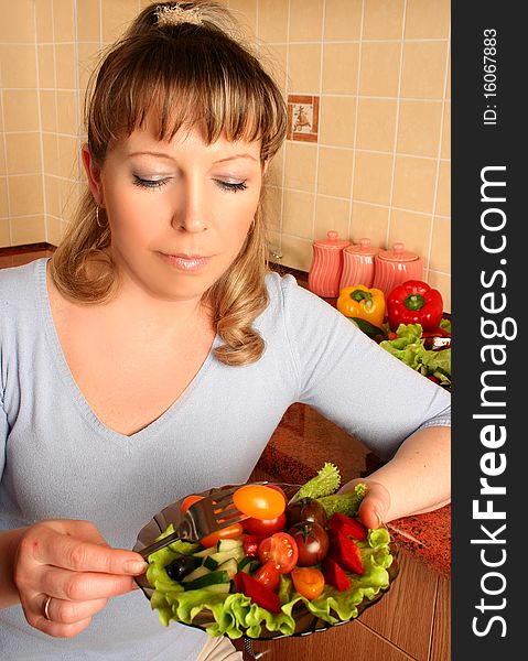 Adult woman preparing salad at domestic kitchen