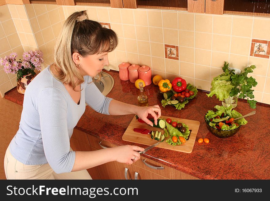 Adult woman preparing salad at domestic kitchen