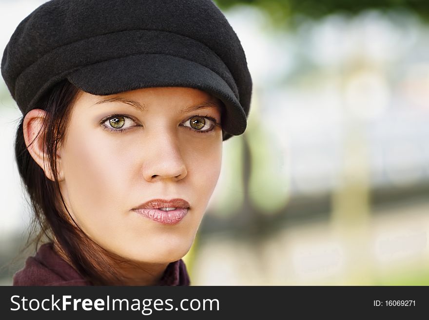 Stylish young woman with cap, outdoors