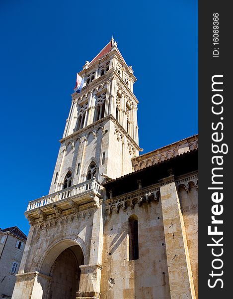 The bell tower of the cathedral against the blue sky, view from below. The bell tower of the cathedral against the blue sky, view from below