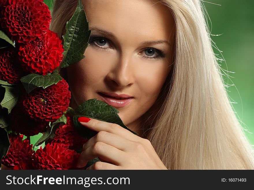 Portrait of a young woman with red flowers on green background. Portrait of a young woman with red flowers on green background