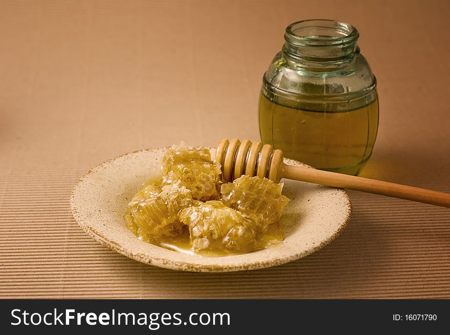 Honeycombs on a plate and jar of honey. Honeycombs on a plate and jar of honey