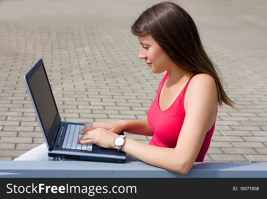 Woman working with a laptop, sitting. Woman working with a laptop, sitting