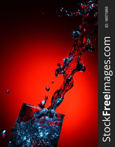 Water in the glass on red background. Water in the glass on red background