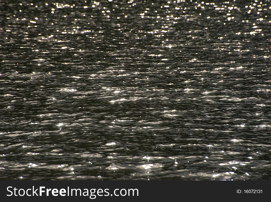 An image of the water surface with bright sunlight reflected from ripples on Coniston Water. An image of the water surface with bright sunlight reflected from ripples on Coniston Water.