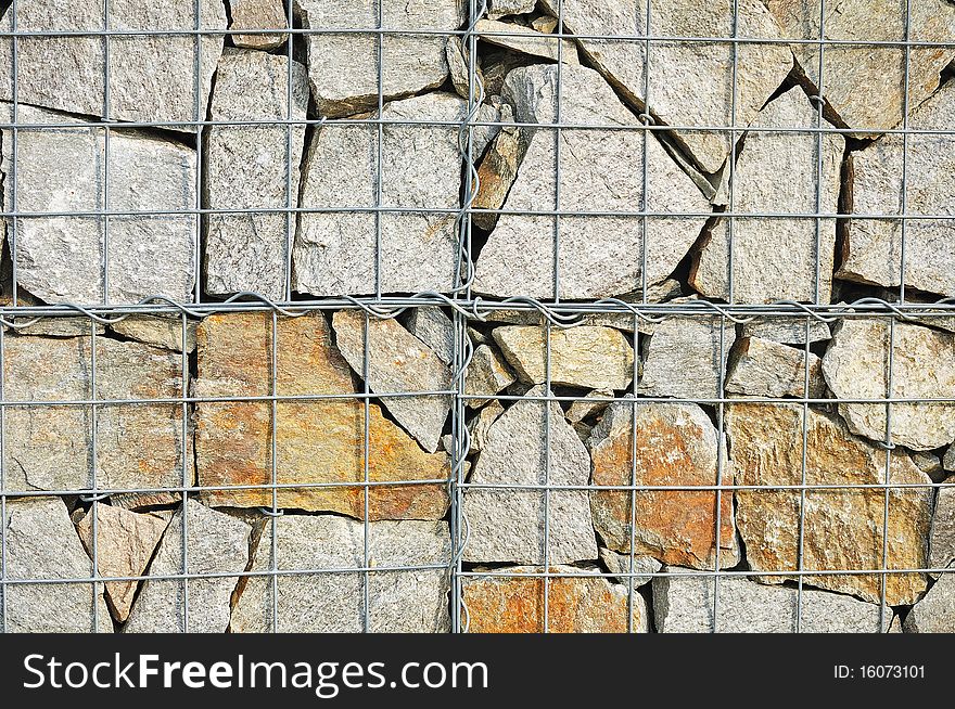 Fragment of wall made of wired cage filled with stones (gabions). Fragment of wall made of wired cage filled with stones (gabions)