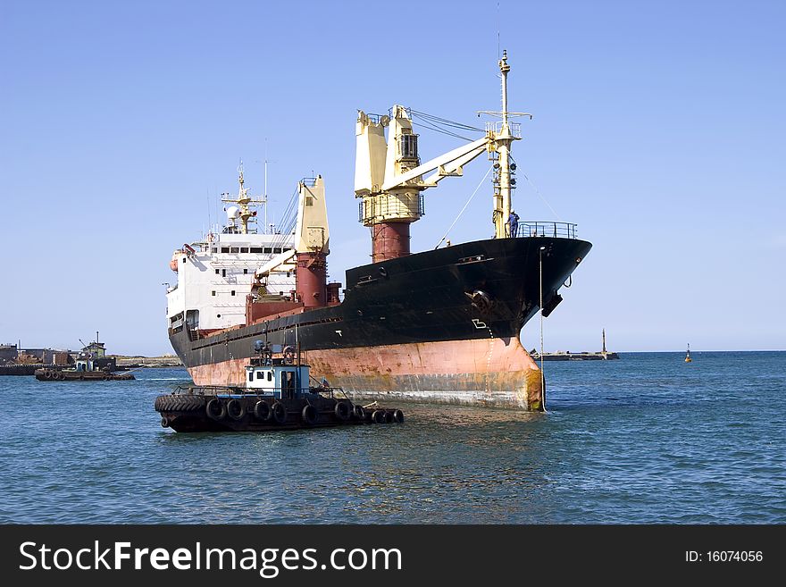 Dry-cargo ship and motorboat in seaport water area. Dry-cargo ship and motorboat in seaport water area