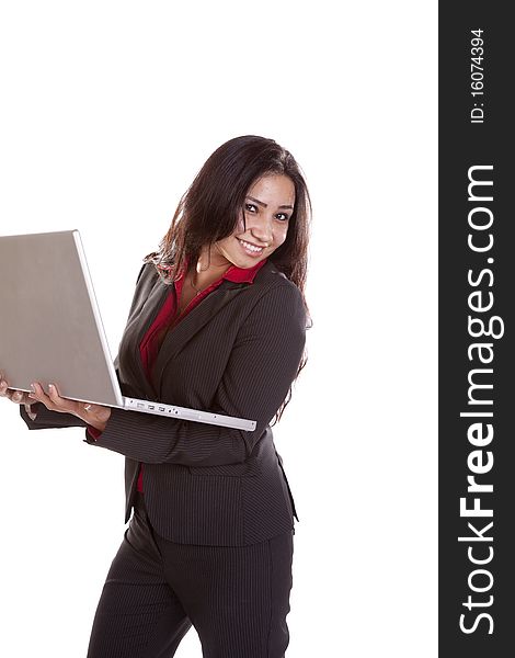 A woman is standing holding a laptop and smiling. A woman is standing holding a laptop and smiling.