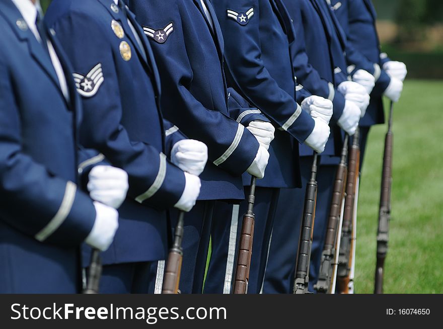 A color guard squad of soldiers in dress uniform with rifles at parade rest