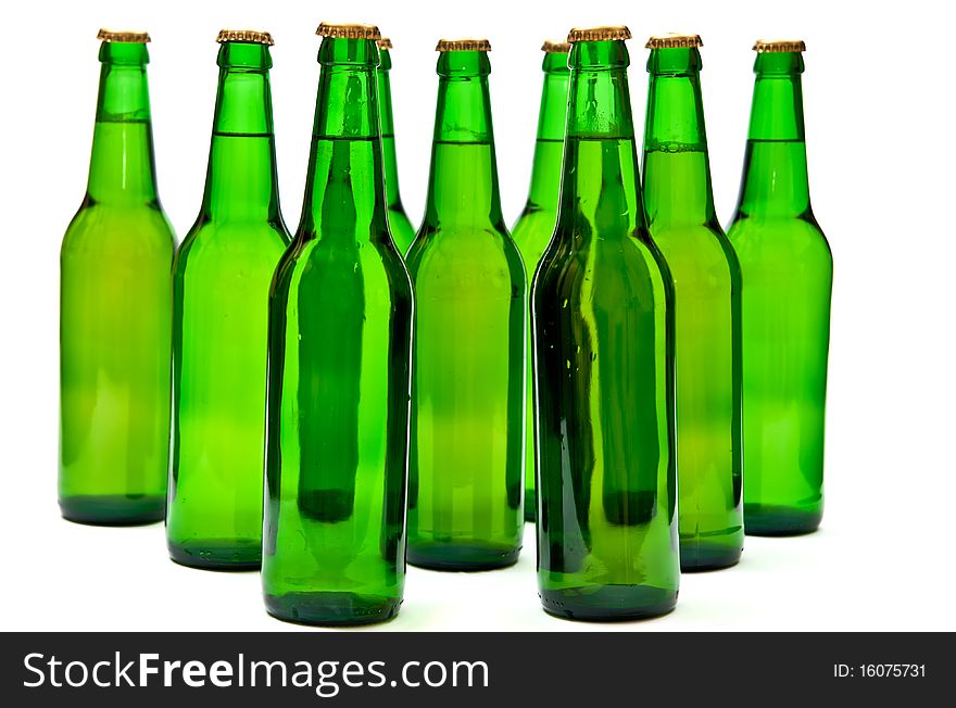 Rows from beer bottles on white background.