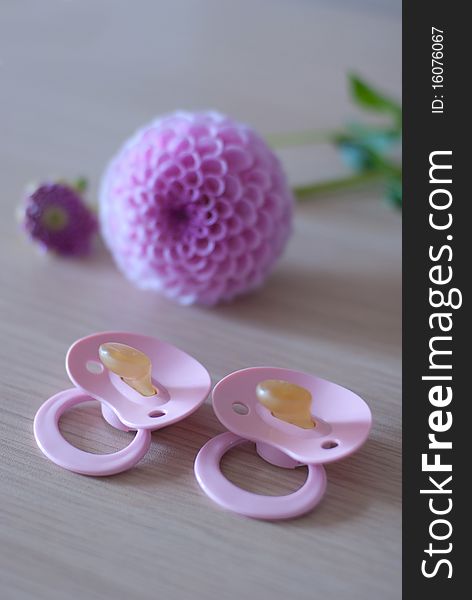 Two baby's pacifier and pink flower