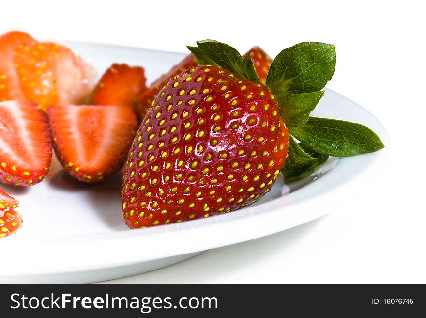 Fresh strawberries on a dish. Chopped and whole