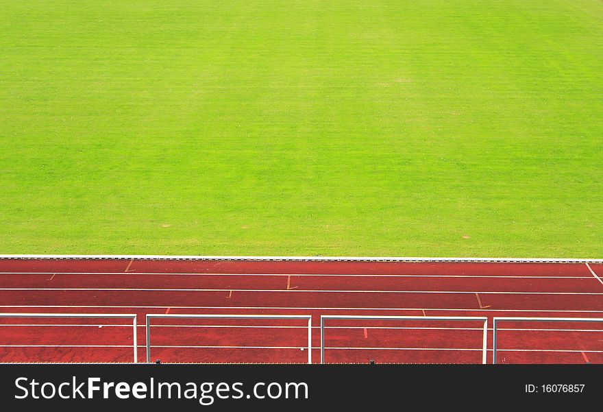 Red athletics track with green field