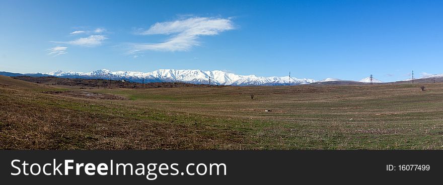 Panorama of spring fields and snowy mountains. Panorama of spring fields and snowy mountains
