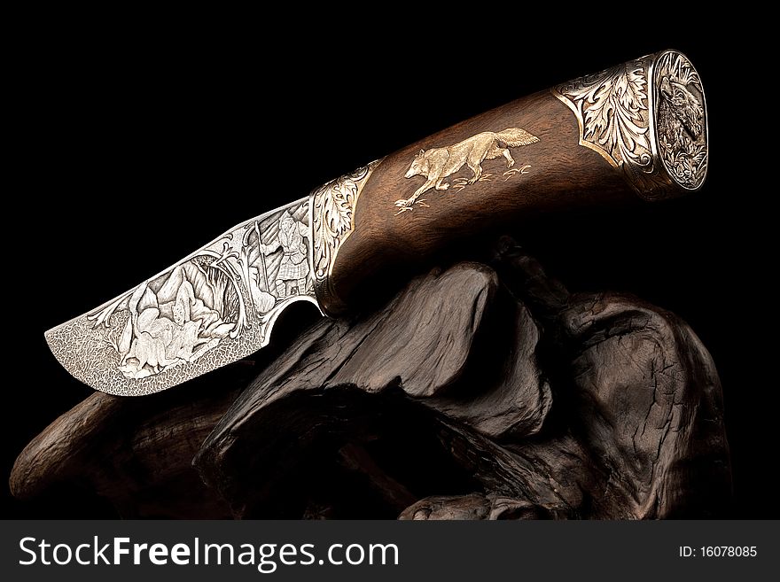 Details of elaborate wildlife and decorative designs on an ornamental hunting knife.