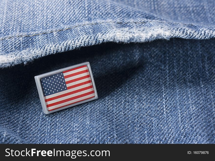 Flag of the USA against a pocket of dark blue jeans trousers.