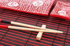Sushi Plates And Chopsticks On Bamboo Mat Royalty Free Stock Image