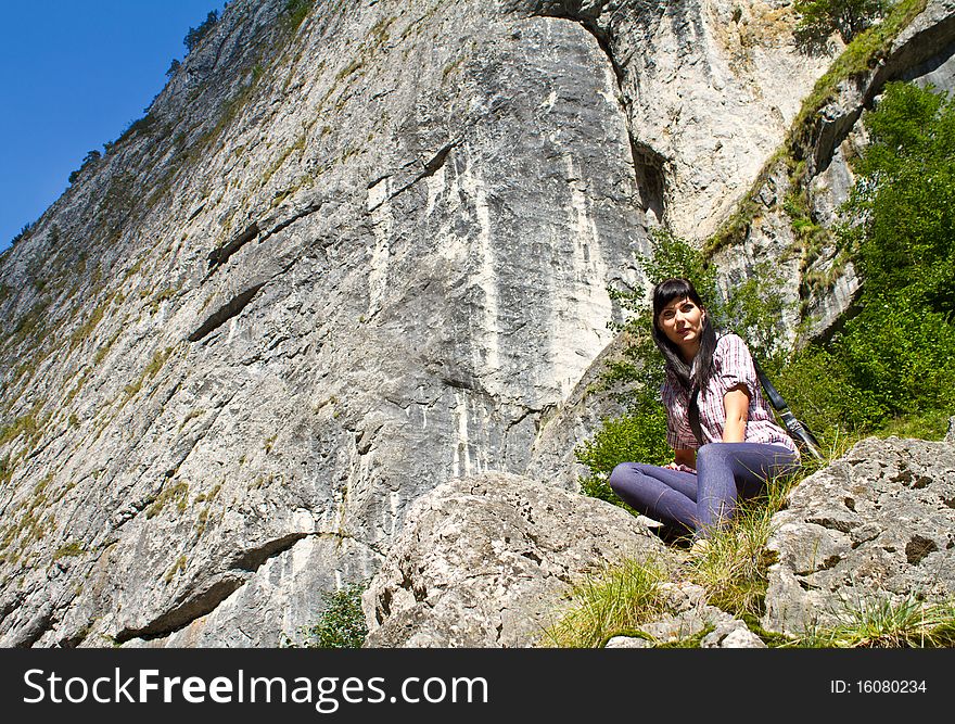 Woman sitting at the edge of a cliff. Woman sitting at the edge of a cliff