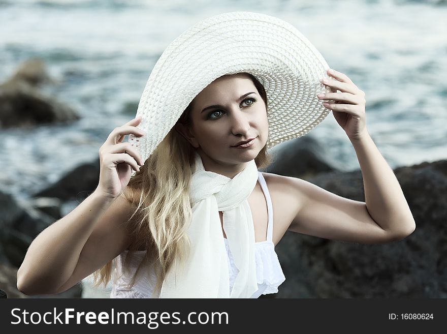 Young beautiful woman posing near the ocean. Young beautiful woman posing near the ocean