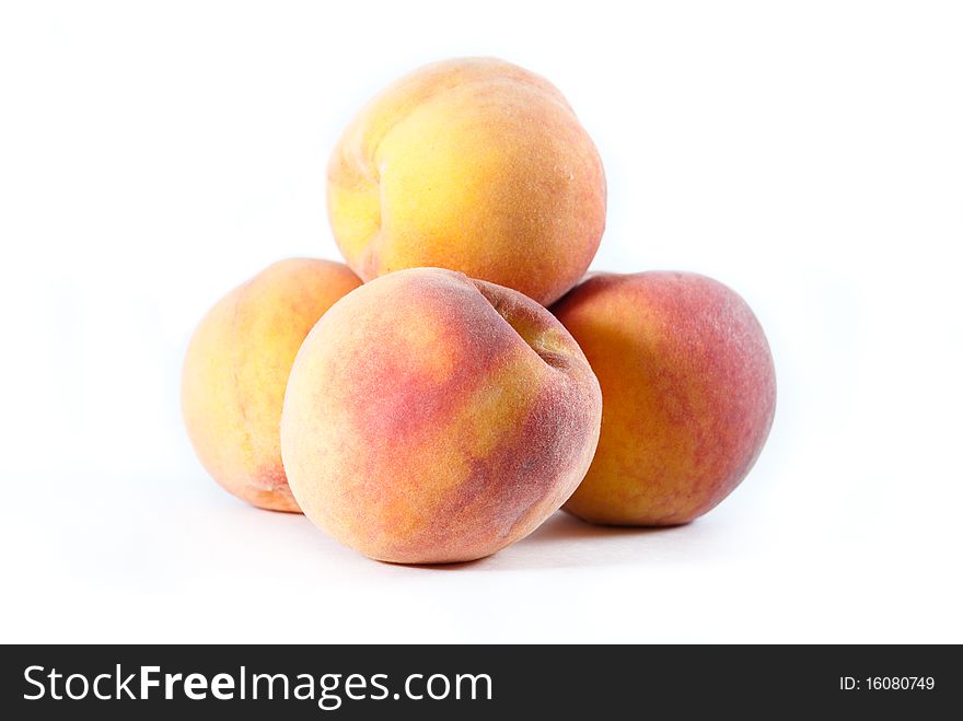 Pile of fuzzy yellow and orange peaches on a white isolated background. Pile of fuzzy yellow and orange peaches on a white isolated background.
