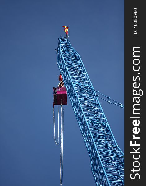 A man bungee jumping off a tall crane