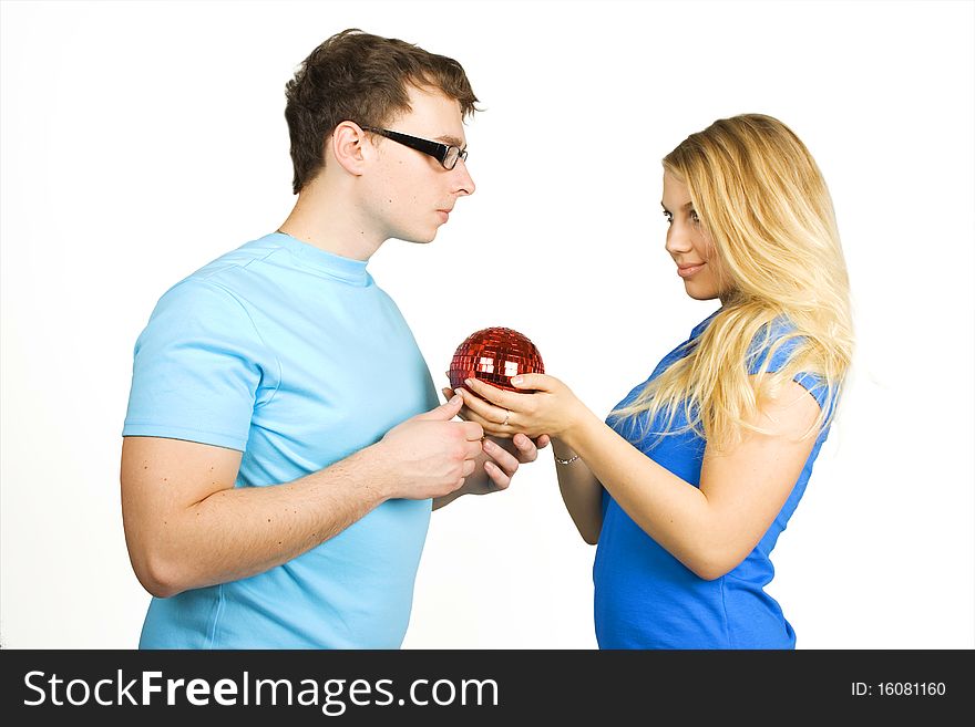 Young man in glasses and beauty blond girl holding red ball for christmas tree isolated on white. Young man in glasses and beauty blond girl holding red ball for christmas tree isolated on white