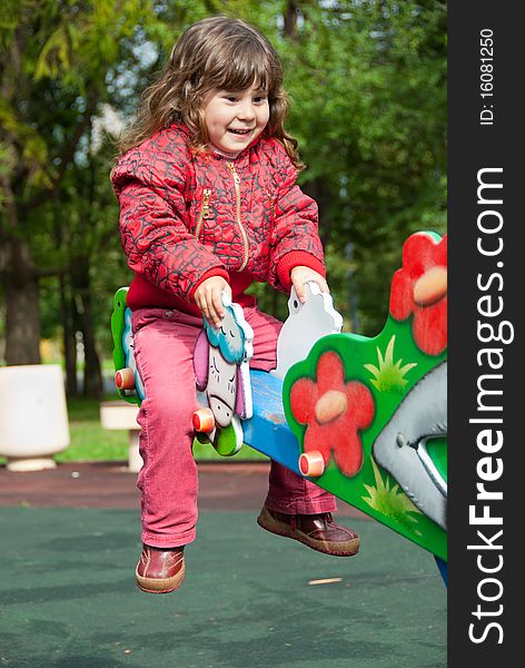 Little girl plays in playground in a park