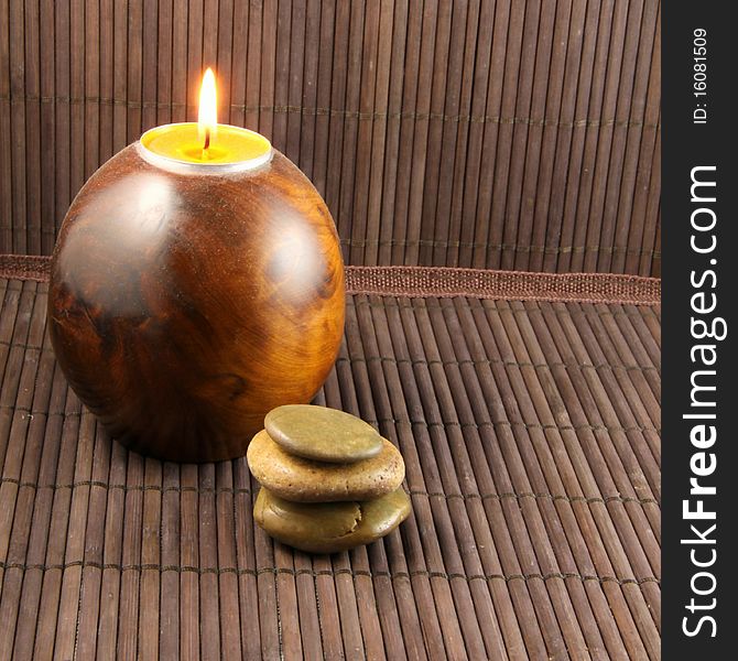 Zen atmosphere with candle, pebbles and bamboo