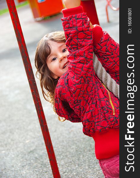 Little girl plays in playground in a park