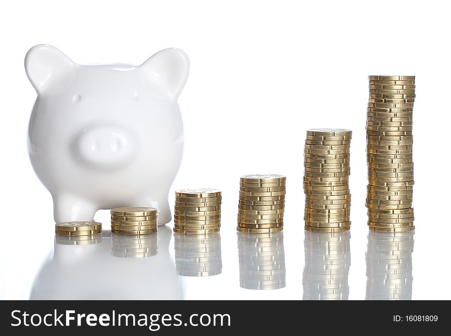 A Piggy Bank is standing behind some stack of coins