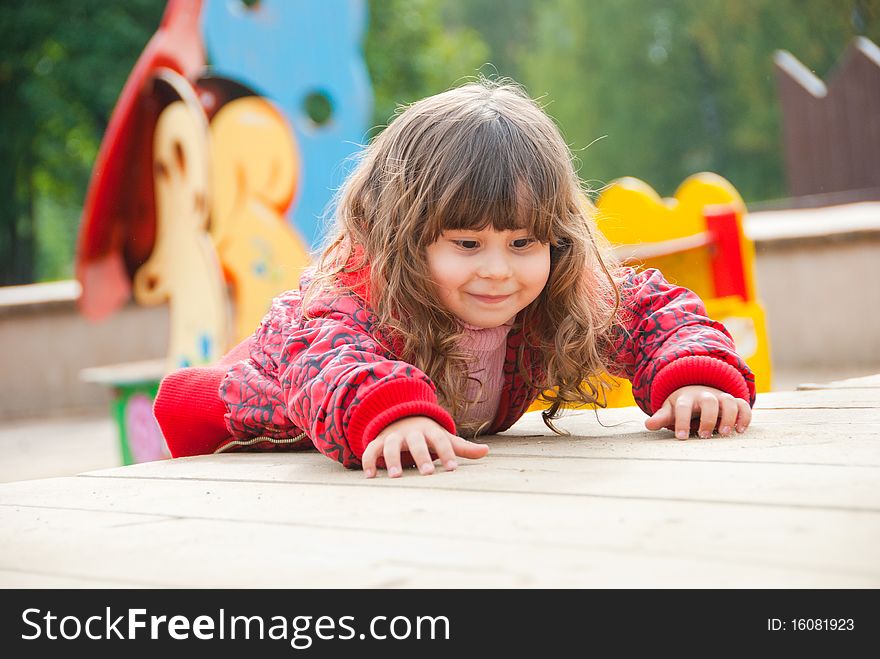 Little girl plays in playground in a park