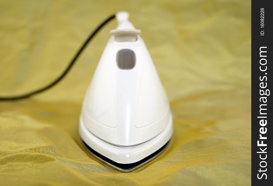 Closeup of electric iron on green cloth. Shallow depth of field. Closeup of electric iron on green cloth. Shallow depth of field.