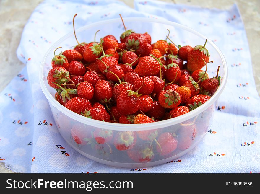 A lot of strawberries in a bowl on the table. A lot of strawberries in a bowl on the table