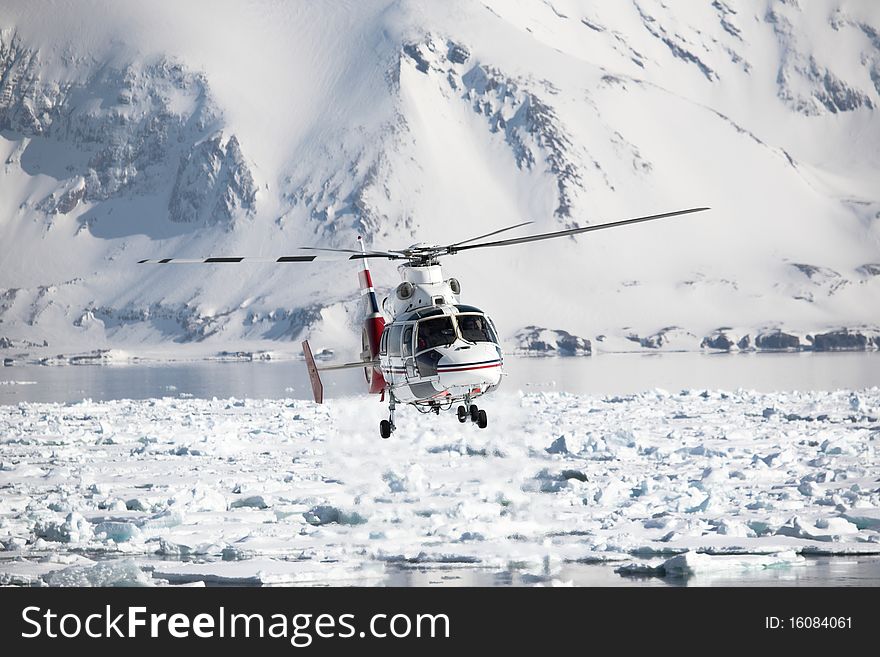 Helicopter in action over the frozen Arctic fjord, Spitsbergen