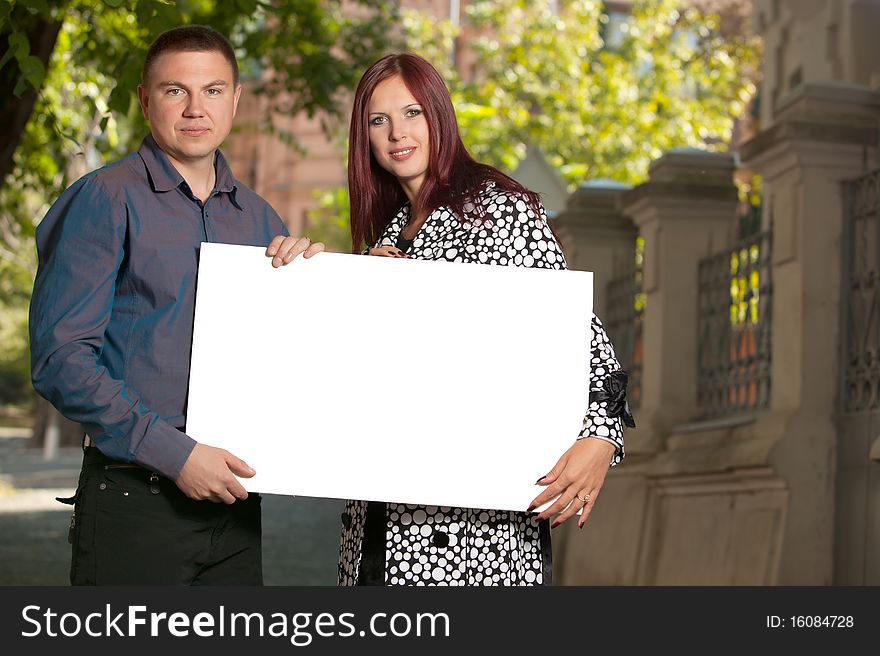 Young couple with blank board