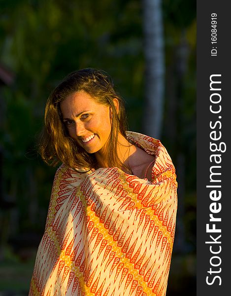 Beautiful woman covered up with a sarong at sunset. Beautiful woman covered up with a sarong at sunset