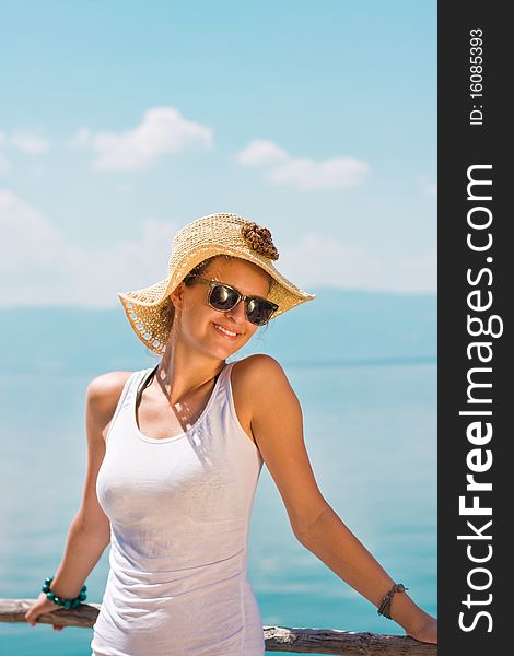 Happy young girl in white tank top at the beach