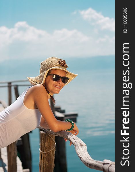 Happy young girl in white tank top at the beach